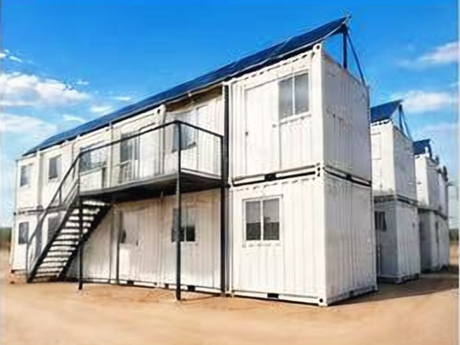 Two-level white container dormitory units with an external steel stair and walkway