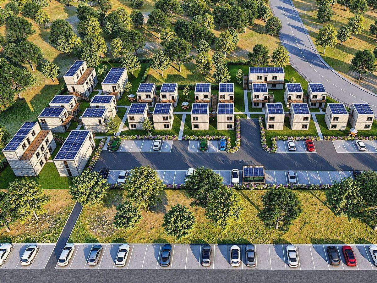 Aerial view of a resort of container cabins with solar roofs among trees and shared parking